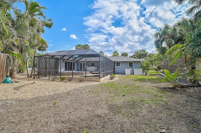 back of property with glass enclosure and a pool