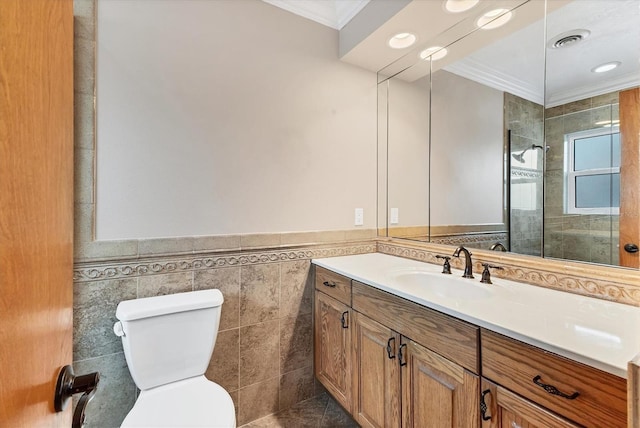 full bathroom with vanity, crown molding, toilet, visible vents, and tile walls