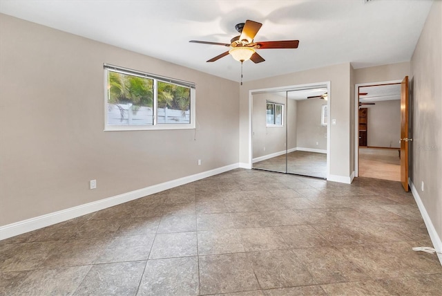 unfurnished bedroom with a closet, baseboards, and a ceiling fan