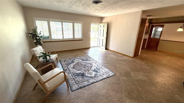 3072 Meyer Dr, Sarasota, FL 34239 - living area with a textured ceiling, baseboards, and tile patterned flooring