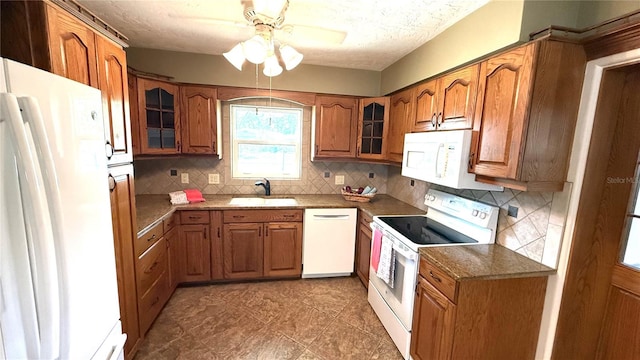 3072 Meyer Dr, Sarasota, FL 34239 - kitchen featuring white appliances, brown cabinetry, a sink, a ceiling fan, and decorative backsplash