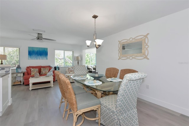 8152 Seashell St, Englewood, FL 34224 - dining area featuring light wood finished floors, ceiling fan, a chandelier, and baseboards
