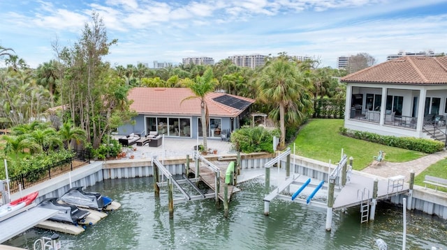 dock area with a water view, a yard, a fenced backyard, and boat lift