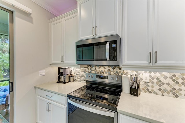 224 Soliera St, Nokomis, FL 34275 - kitchen featuring white cabinetry, light countertops, crown molding, decorative backsplash, and appliances with stainless steel finishes