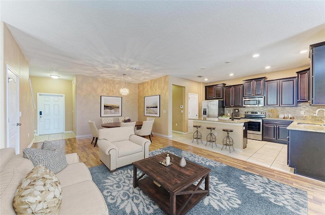 1912 Hawks View Dr, Ruskin, FL 33570 - living room featuring baseboards, light wood-type flooring, recessed lighting, and a textured ceiling