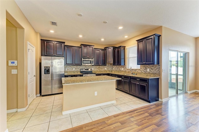 1912 Hawks View Dr, Ruskin, FL 33570 - kitchen with dark brown cabinetry, a kitchen island, visible vents, stainless steel appliances, and a sink