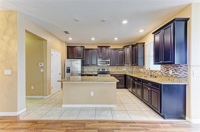1912 Hawks View Dr, Ruskin, FL 33570 - kitchen with light stone countertops, visible vents, a kitchen island, appliances with stainless steel finishes, and a sink