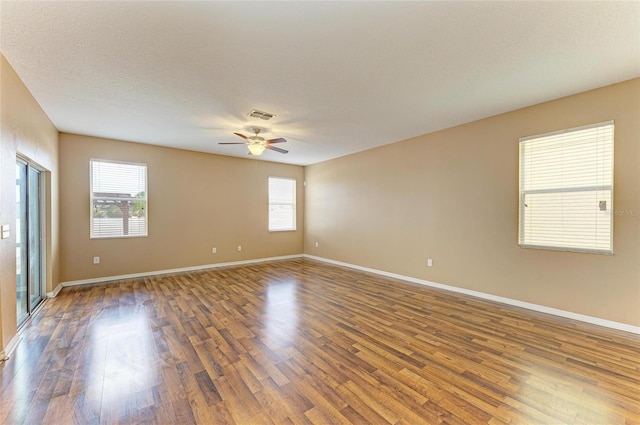1912 Hawks View Dr, Ruskin, FL 33570 - empty room with visible vents, ceiling fan, plenty of natural light, and wood finished floors