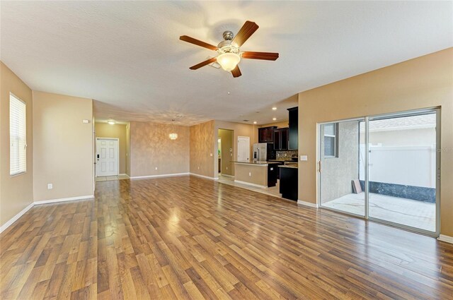1912 Hawks View Dr, Ruskin, FL 33570 - unfurnished living room featuring light wood-type flooring, ceiling fan, and baseboards