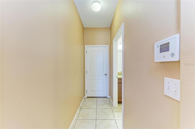 1912 Hawks View Dr, Ruskin, FL 33570 - corridor featuring a textured ceiling, baseboards, and light tile patterned flooring