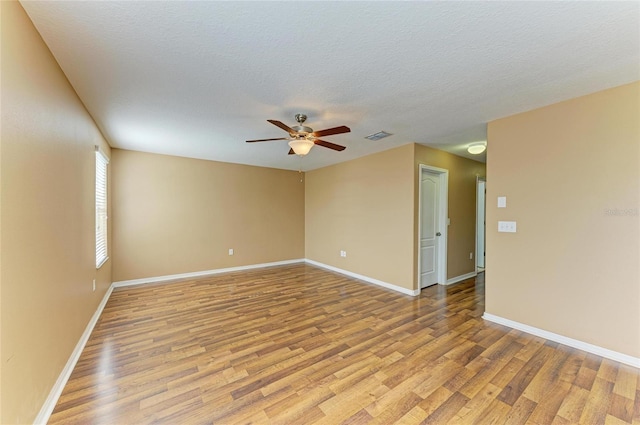 1912 Hawks View Dr, Ruskin, FL 33570 - spare room with baseboards, light wood-style flooring, a textured ceiling, visible vents, and ceiling fan