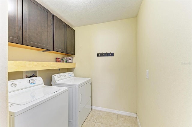 1912 Hawks View Dr, Ruskin, FL 33570 - laundry area featuring light tile patterned floors, a textured ceiling, washer and dryer, baseboards, and cabinet space