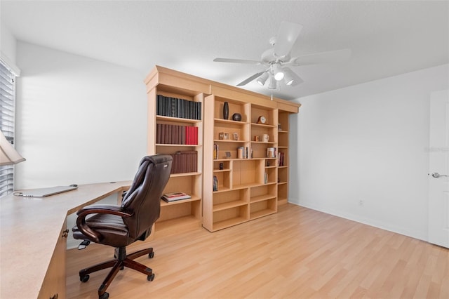 office featuring light wood-style floors, a textured ceiling, and a ceiling fan
