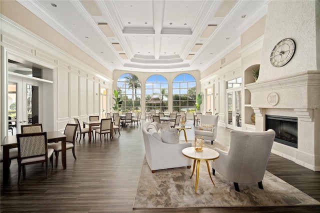 living area with ornamental molding, a towering ceiling, a premium fireplace, and dark wood-style floors