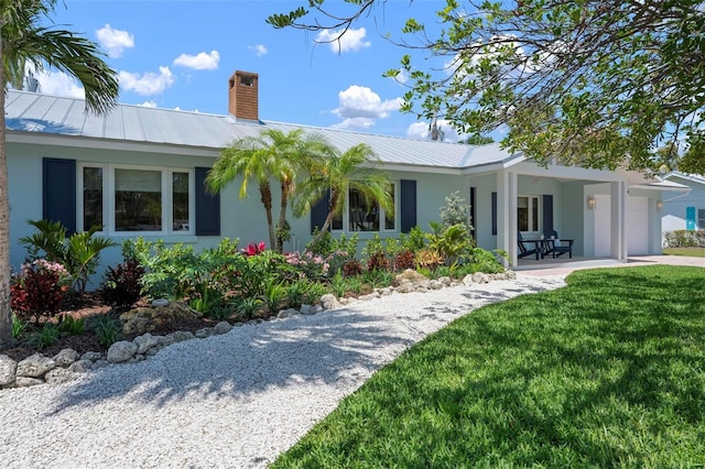 ranch-style home featuring metal roof, stucco siding, and an attached garage