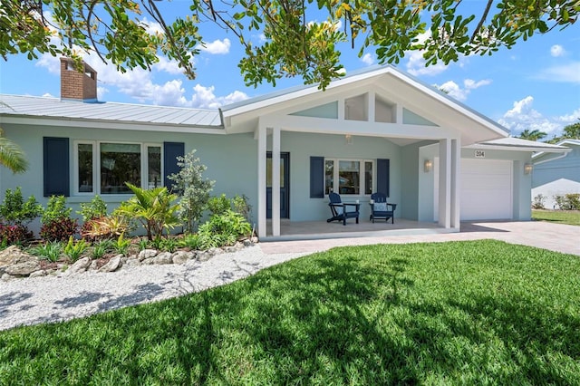 exterior space with concrete driveway, stucco siding, a chimney, an attached garage, and a yard