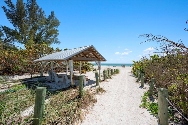 view of property's community featuring a water view, a gazebo, and a view of the beach