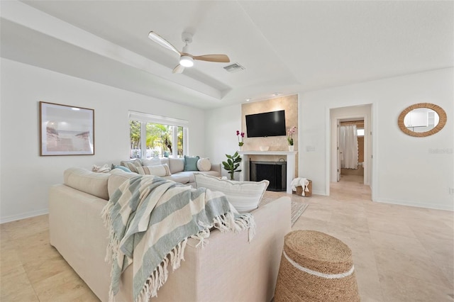 living area featuring light tile patterned floors, a ceiling fan, a large fireplace, visible vents, and baseboards