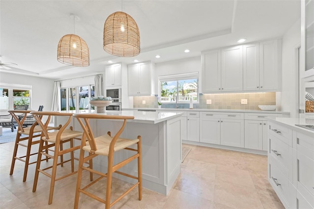 kitchen featuring tasteful backsplash, a kitchen island, stainless steel oven, and recessed lighting
