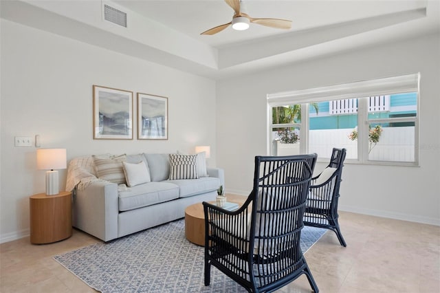 living room featuring baseboards, a raised ceiling, light tile patterned flooring, visible vents, and ceiling fan