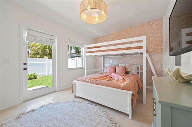 bedroom with access to outside, a chandelier, and wallpapered walls