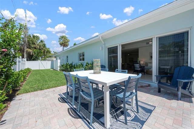 view of patio / terrace featuring outdoor dining space, fence, and a gate