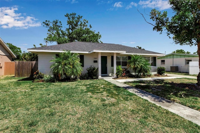 ranch-style house with a front yard, fence, and central AC