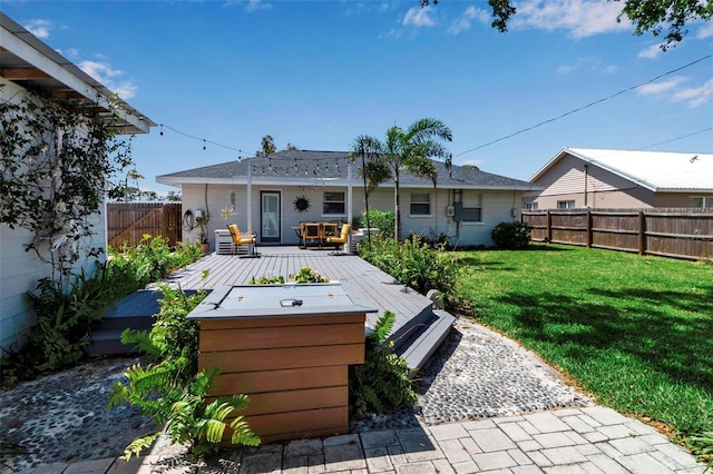 rear view of property featuring a deck, a fenced backyard, and a lawn