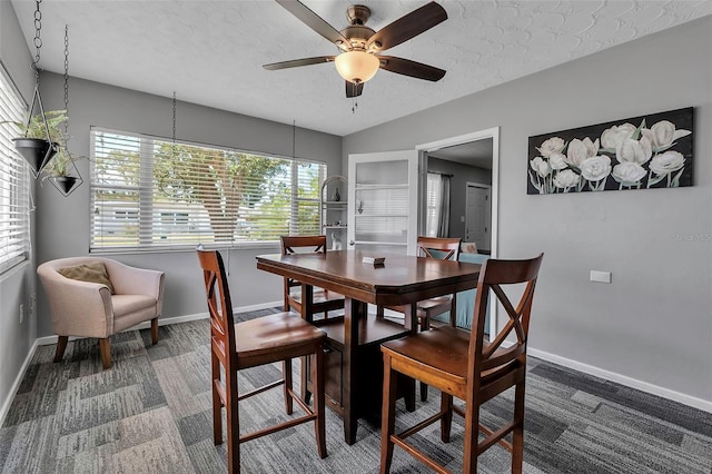 dining space with a textured ceiling, a ceiling fan, vaulted ceiling, carpet flooring, and baseboards