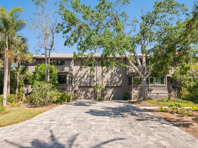 1493 Landings Lake Dr Unit 32, Sarasota, FL 34231 - bi-level home featuring decorative driveway, covered porch, a balcony, and a garage