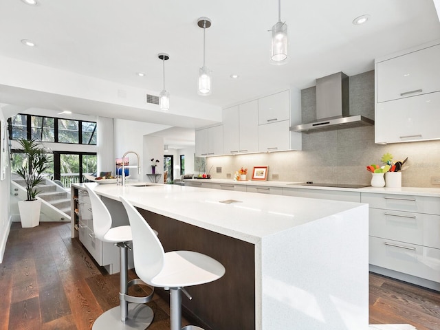 1493 Landings Lake Dr Unit 32, Sarasota, FL 34231 - kitchen featuring black electric cooktop, dark wood-style flooring, modern cabinets, and wall chimney range hood
