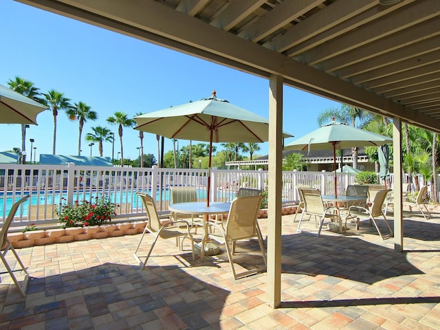 1493 Landings Lake Dr Unit 32, Sarasota, FL 34231 - view of patio with a community pool, outdoor dining space, and fence