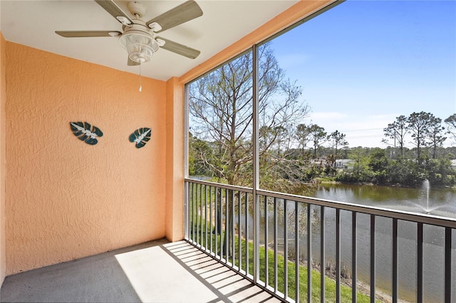 balcony featuring a water view and ceiling fan