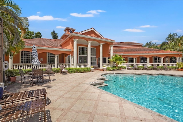 community pool with a patio area and fence