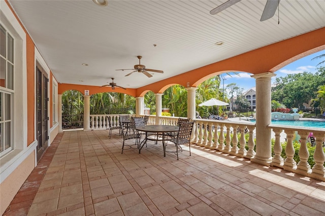 view of patio / terrace with an outdoor pool, outdoor dining area, and a ceiling fan