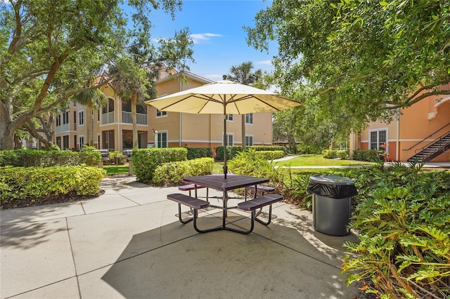 view of property's community featuring outdoor dining space and a patio