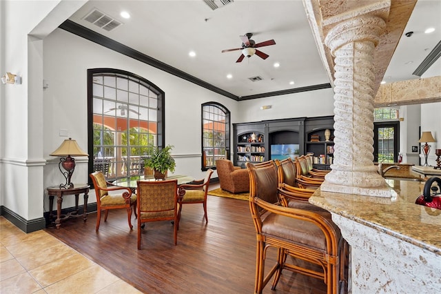 dining space featuring visible vents, a wealth of natural light, decorative columns, a ceiling fan, and crown molding