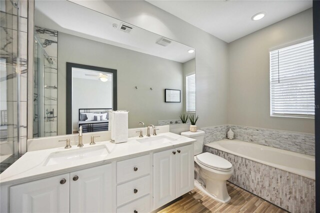 1586 Dorgali Dr, Sarasota, FL 34238 - bathroom with healthy amount of natural light, wood finished floors, a garden tub, toilet, and recessed lighting