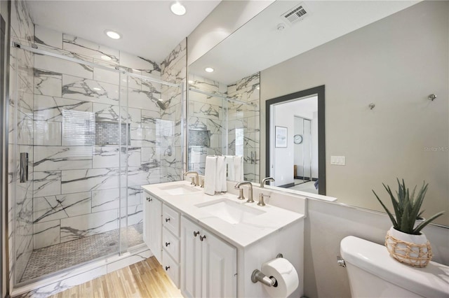 1586 Dorgali Dr, Sarasota, FL 34238 - bathroom featuring toilet, double vanity, a marble finish shower, recessed lighting, and wood finished floors