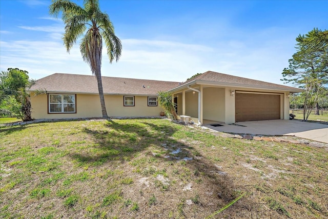 ranch-style house featuring concrete driveway, an attached garage, a front lawn, and stucco siding