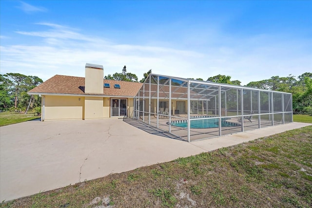 pool with a patio area and glass enclosure
