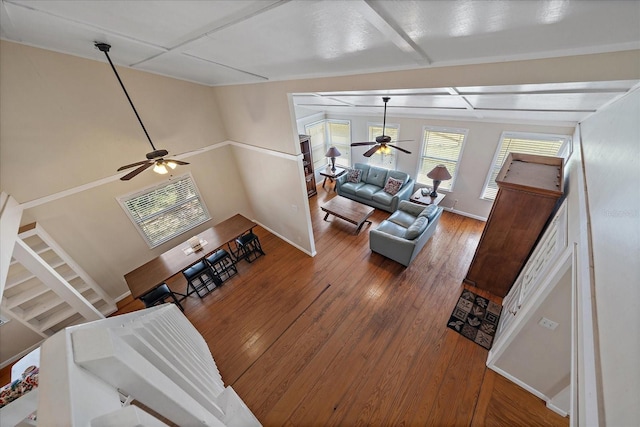 living area with baseboards, a ceiling fan, and hardwood / wood-style flooring