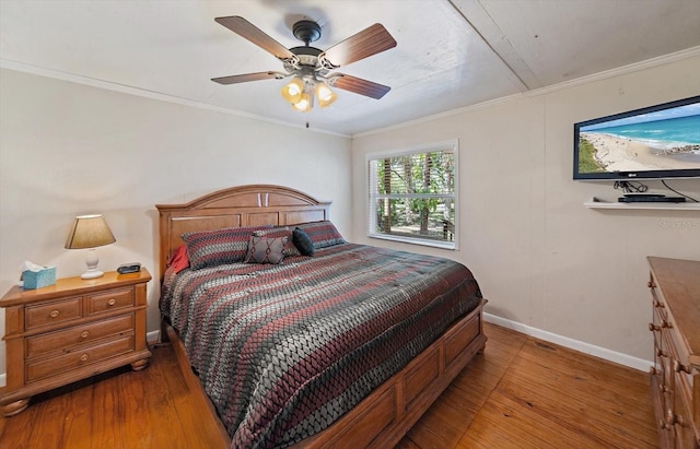 bedroom featuring ornamental molding, baseboards, a ceiling fan, and hardwood / wood-style floors
