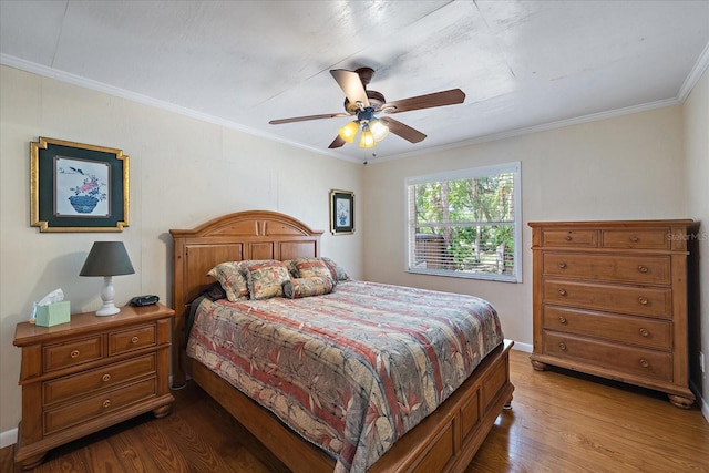bedroom featuring crown molding, a ceiling fan, and wood finished floors