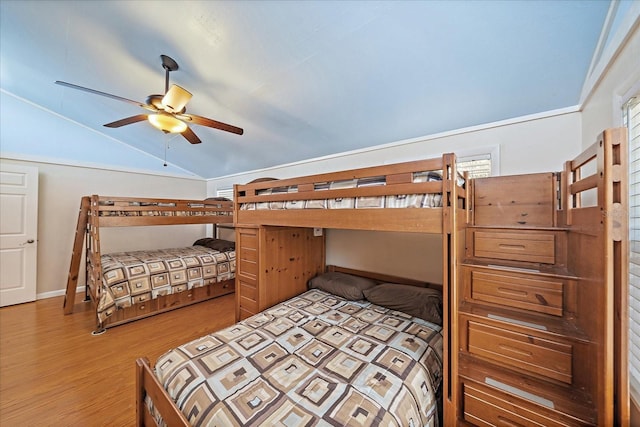 bedroom with wood finished floors and lofted ceiling