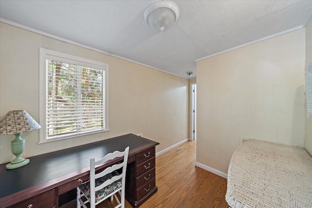 home office with built in desk, baseboards, and light wood-type flooring