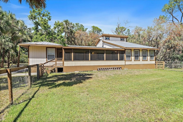 view of front of property featuring a sunroom, fence, and a front lawn