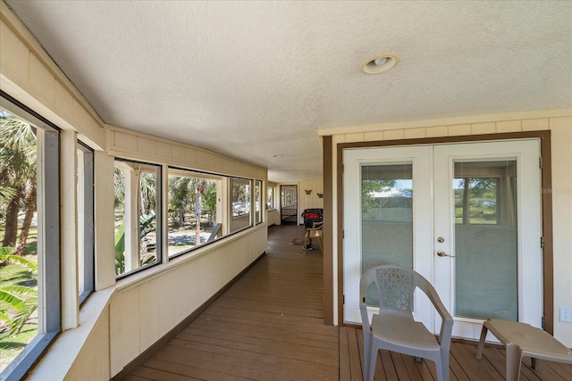 sunroom with hardwood / wood-style floors, french doors, and a textured ceiling