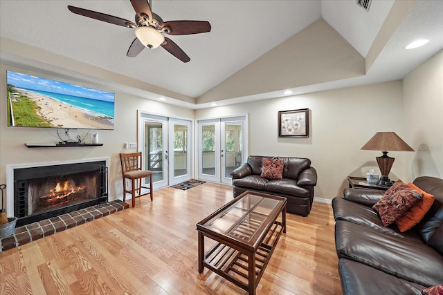 living room featuring a fireplace, french doors, a ceiling fan, visible vents, and wood finished floors