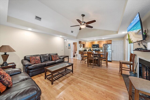 living area featuring visible vents, high vaulted ceiling, a ceiling fan, and light wood finished floors